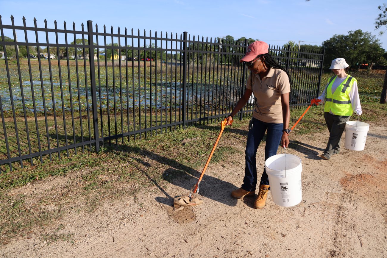 Volunteers clearing trash along a Deltona lakeshore